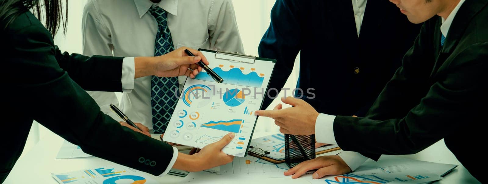 Business people in group meeting in formal attire share idea discussing report for company profit in creative workspace for start up business shot in close up view on group meeting table . Oratory .