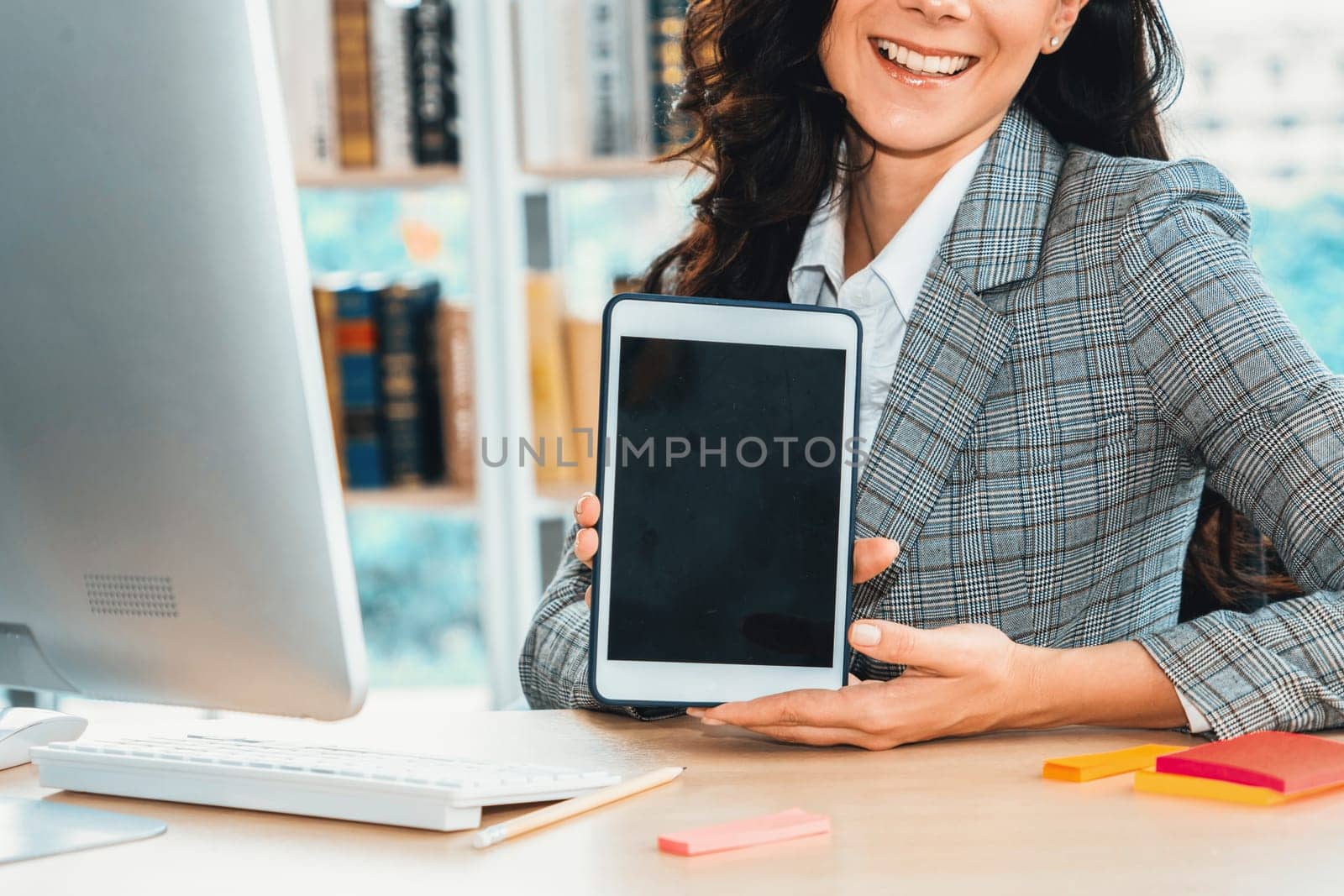 Empty tablet computer screen shown by woman in office for product , website and mobile app presentation. Jivy