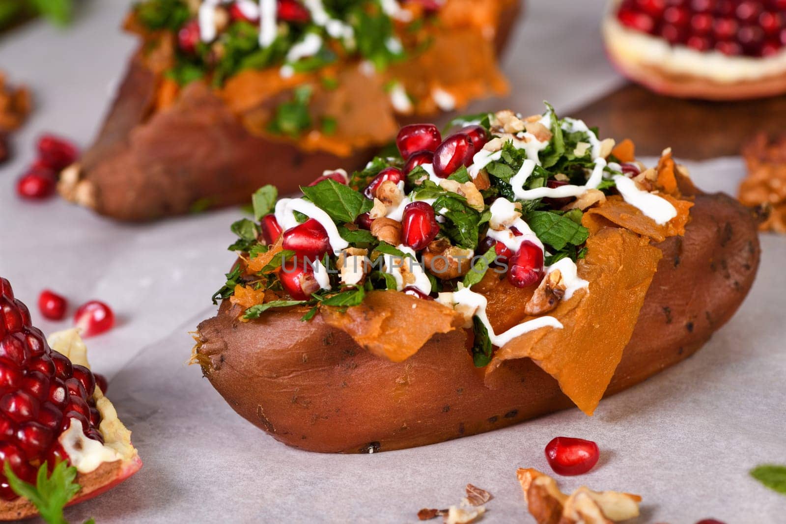 Baked stuffed sweet potatoes filled with walnuts, fresh herbs, mint and pomegranate seeds. The tahini sauce makes them excellent. It is a healthy side dish or main dish for vegans and paleo.