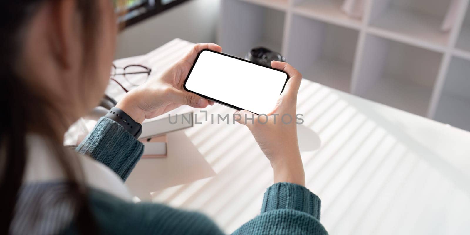 Mobile phone display blank white screen mockup. woman hand holding smartphone with horizontal for advertisement.