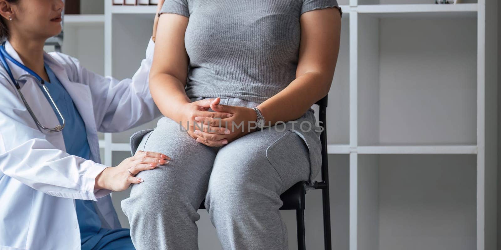 Overweight fat woman having consultation at the office. portrait of friendly smiling doctor putting hand on shoulder supporting patient, giving consultation during medical examination in clinic.