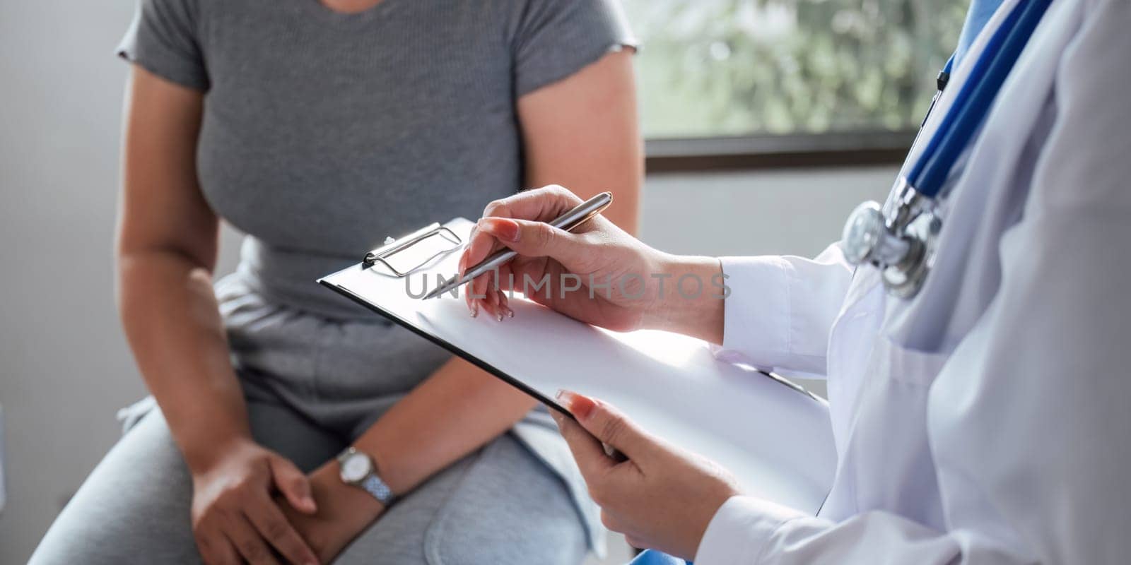 Overweight fat woman having consultation at the office. portrait of friendly smiling doctor putting hand on shoulder supporting patient, giving consultation during medical examination in clinic.