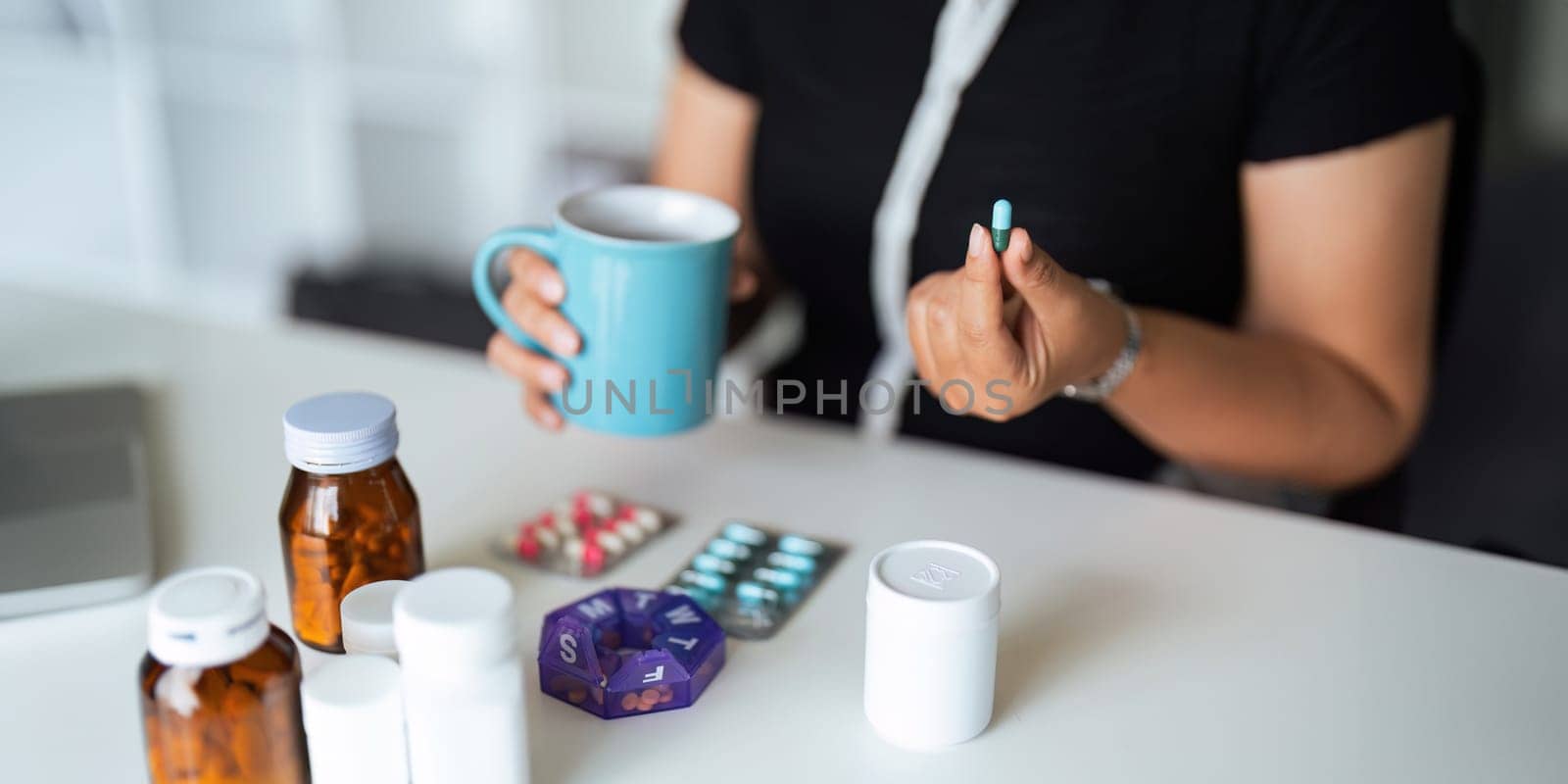 Close up woman holding pill in hand with water feeling sick. female going to take painkiller from headache, painkiller, healthcare, medicine, treatment, therapy, patient, disease illness concept by nateemee