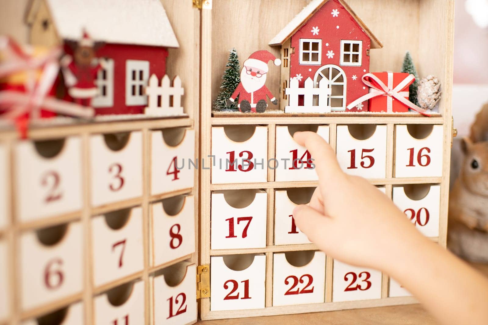 Hand of child opens wooden advent calendar