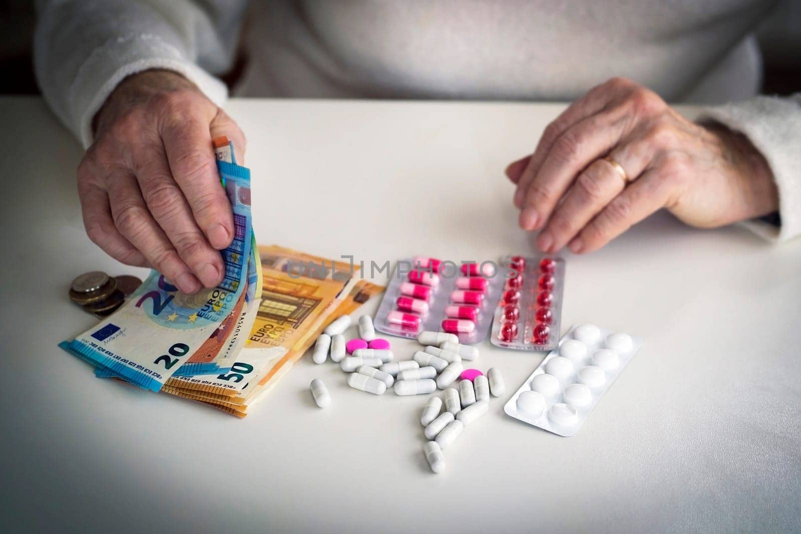 An older retired woman is counting money and saving it for medicines, medical treatment and insurance. Taking care of your health and wise investment.