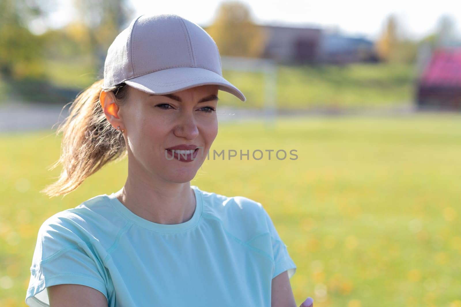 A young beautiful woman in sportswear plays sports at a local stadium. Exercise, jog and exercise at the beginning of the day. Healthy and active lifestyle.