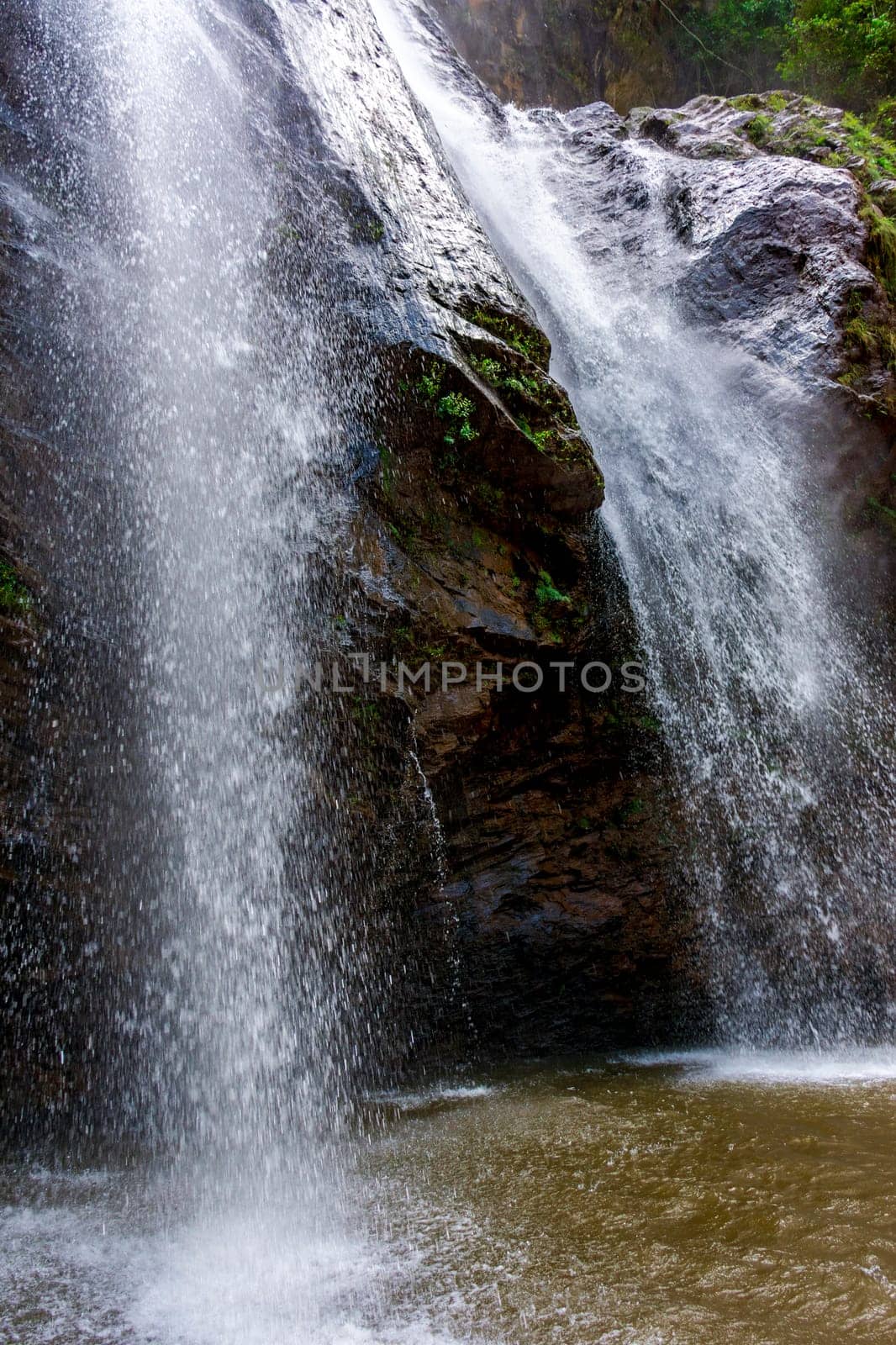 Water from the waterfall splashing through the rocks into a water well in Minas Gerais, Brazil