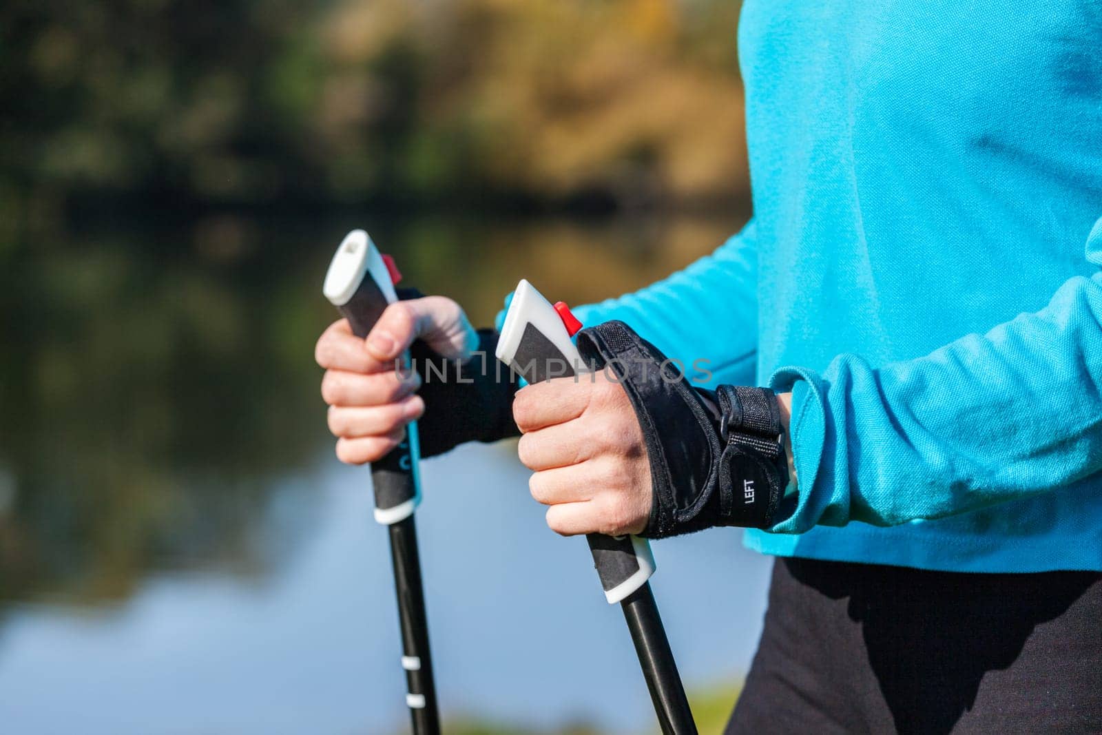Closeup of woman's hand with nordic walking poles by dimol