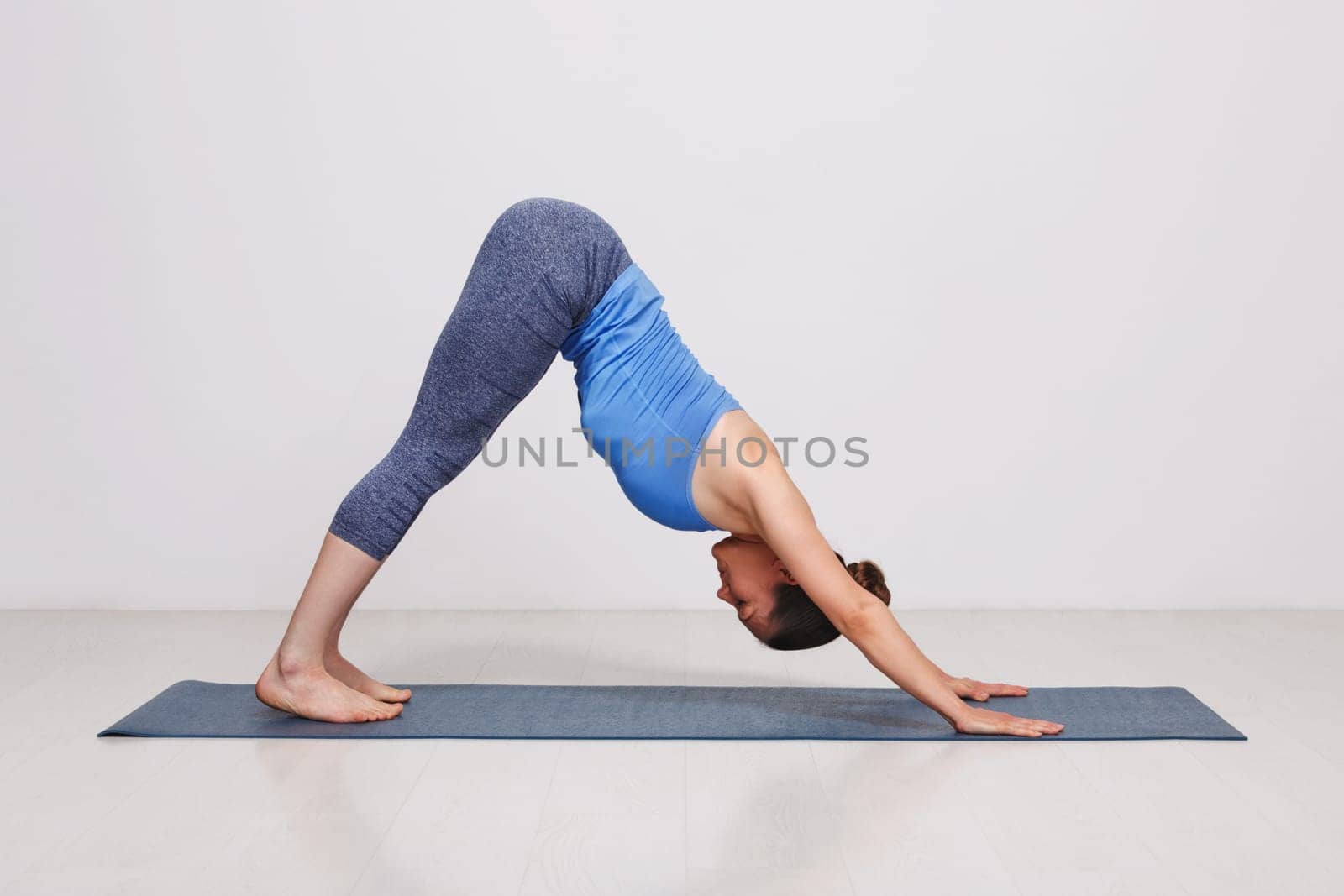 Woman doing Ashtanga Vinyasa yoga asana Adhomukha svanasana by dimol