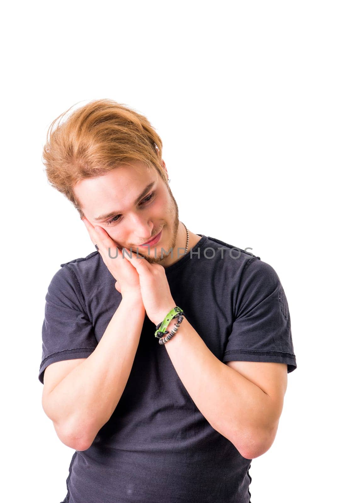 A young blond attractive man with a dreaming expression, thinking with a smile on his face