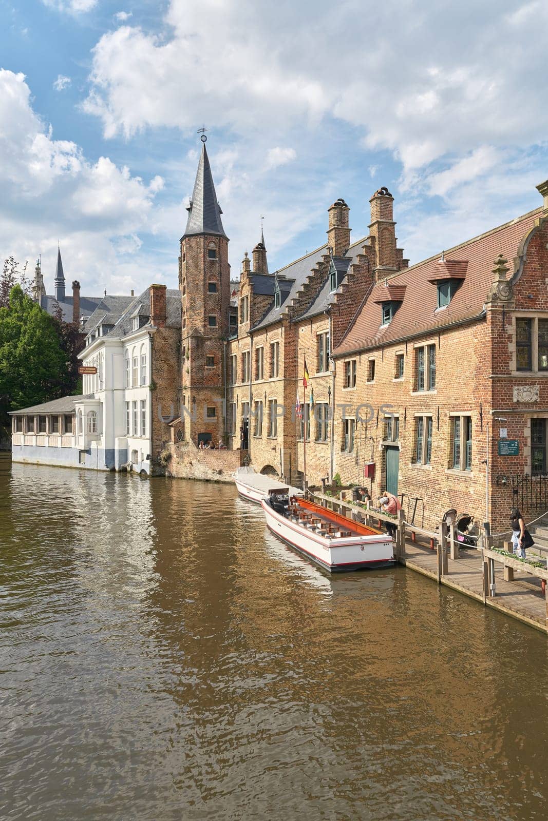 Bruges, Belgium – May 13, 2024: Canal at Rozenhoedkaai, in the old town of Bruges in Belgium with excursion boats for tourists