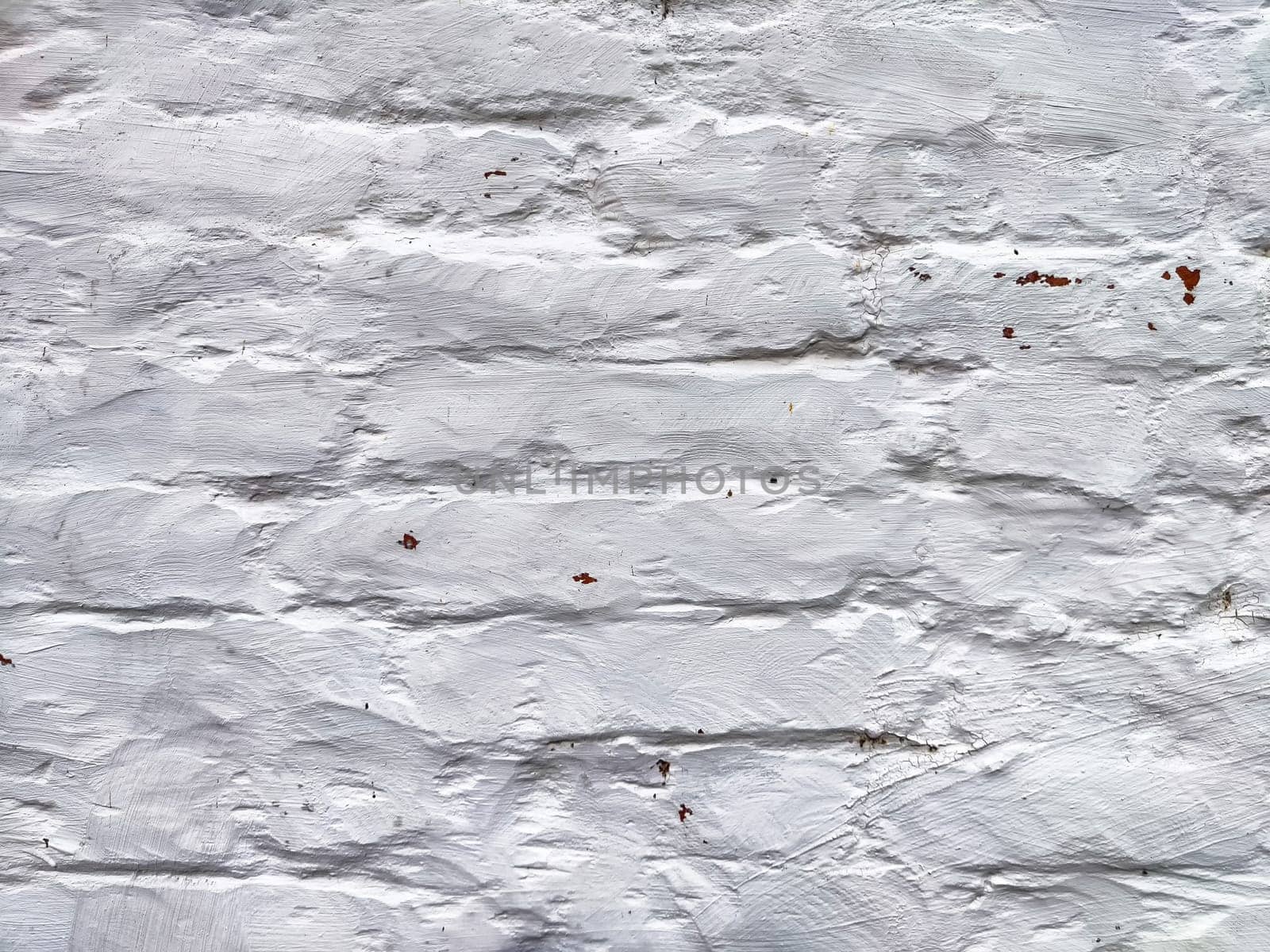 The surface features a textured white finish, emphasizing its imperfect and rustic qualities, reflecting years of exposure and wear.