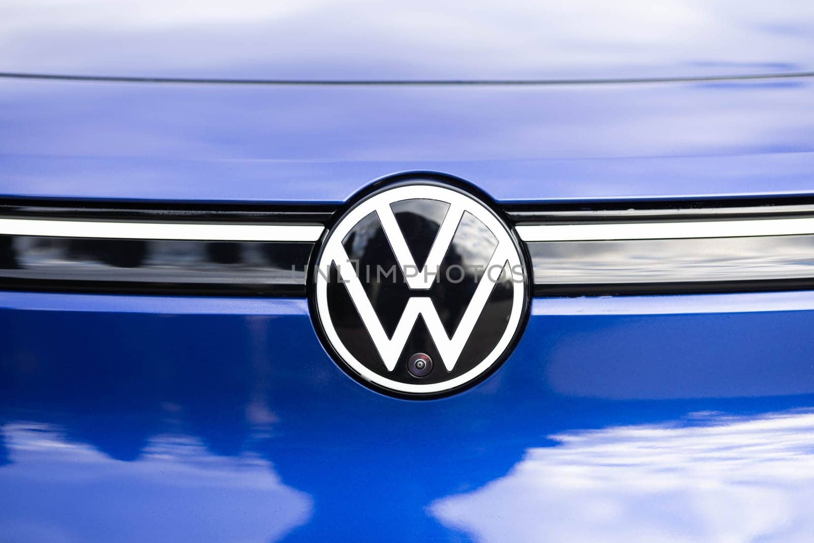 Close up of front view VW ID.4 camera on a front grille mesh of the car. Parking assist systems. front view camera for parking assistance. Surround View 360 Degrees camera. SUV Volkswagen ID4 logo