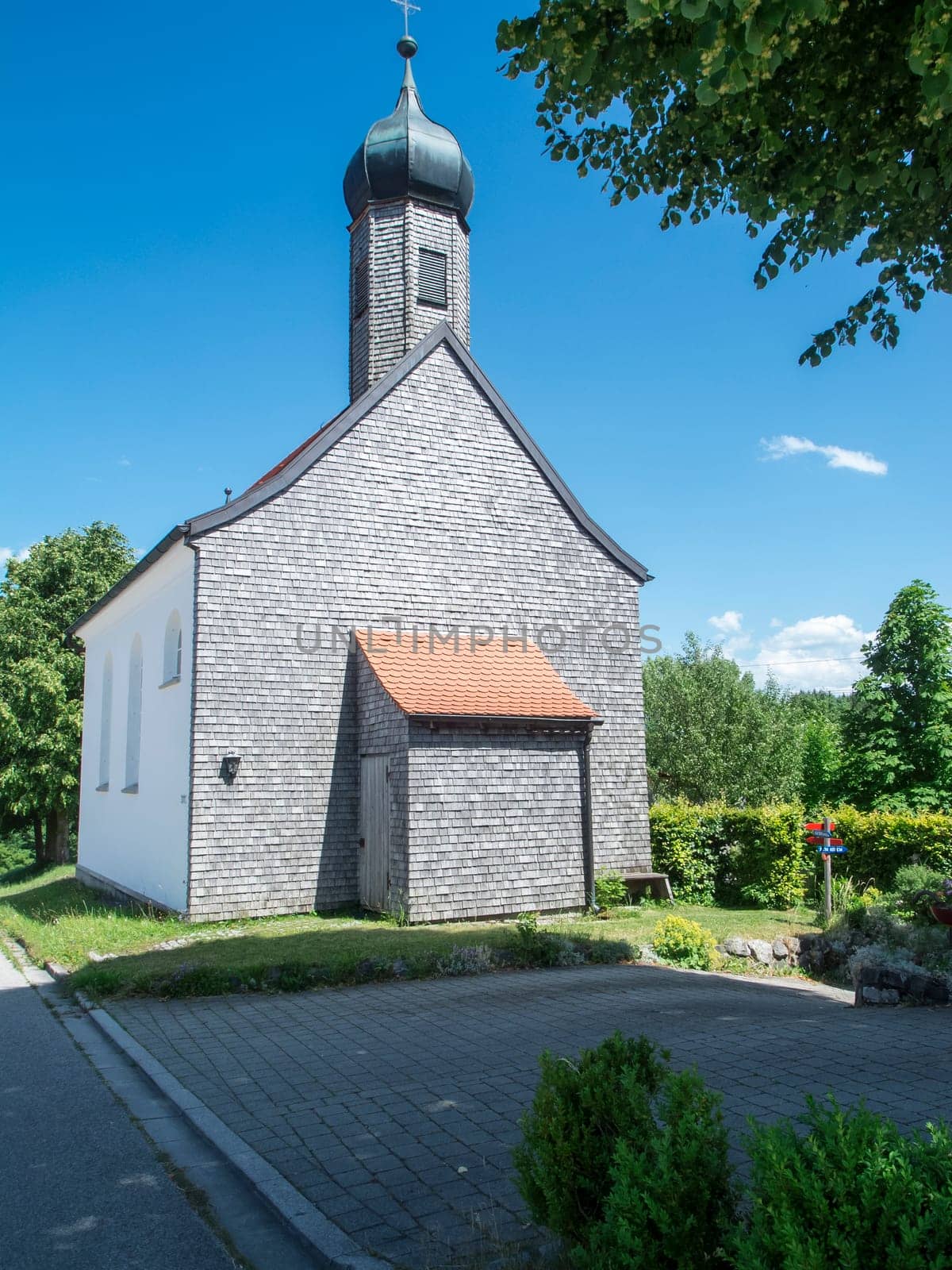 Small chapel in Oy-Small chapel Unterreuten Seeg in Bavaria Ostallgäu in summer against a blue sky. The chapel was built in 1817 and damaged by lightning in July 1927. The new building and inauguration took place in 1930.