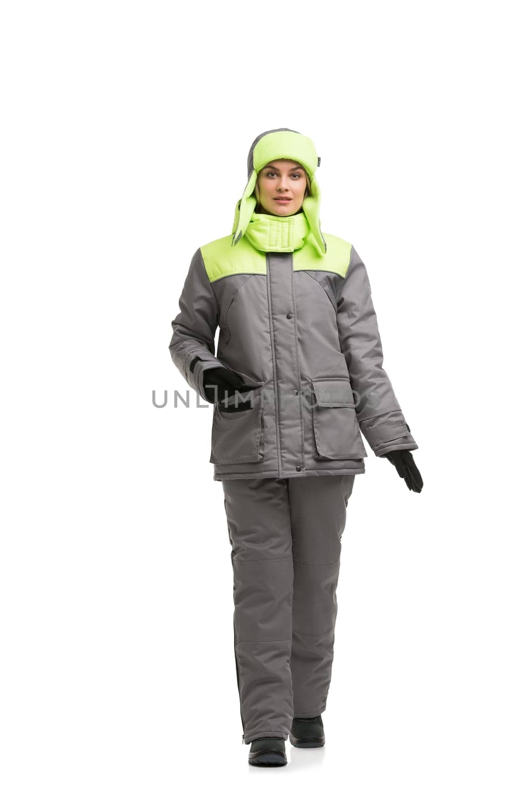 Female in gray and yellow working trousers and jacket and cap isolated full-length view