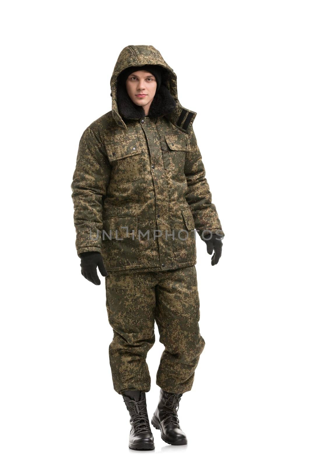 Man in khaki working clothes with a hood on and high shoes with lacing isolated full-length view