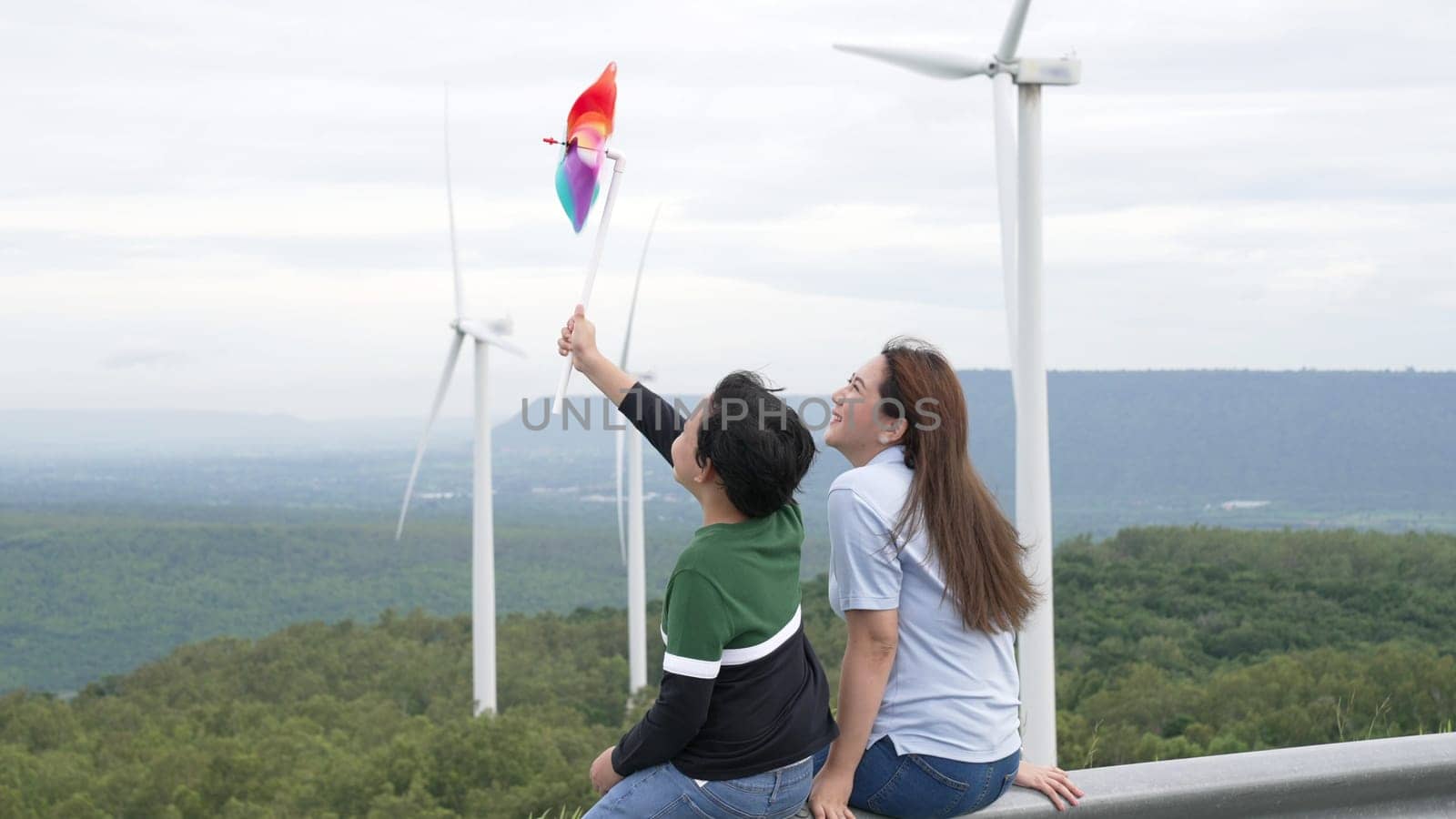 Progressive happy mother and her son at the wind turbine farm. by biancoblue