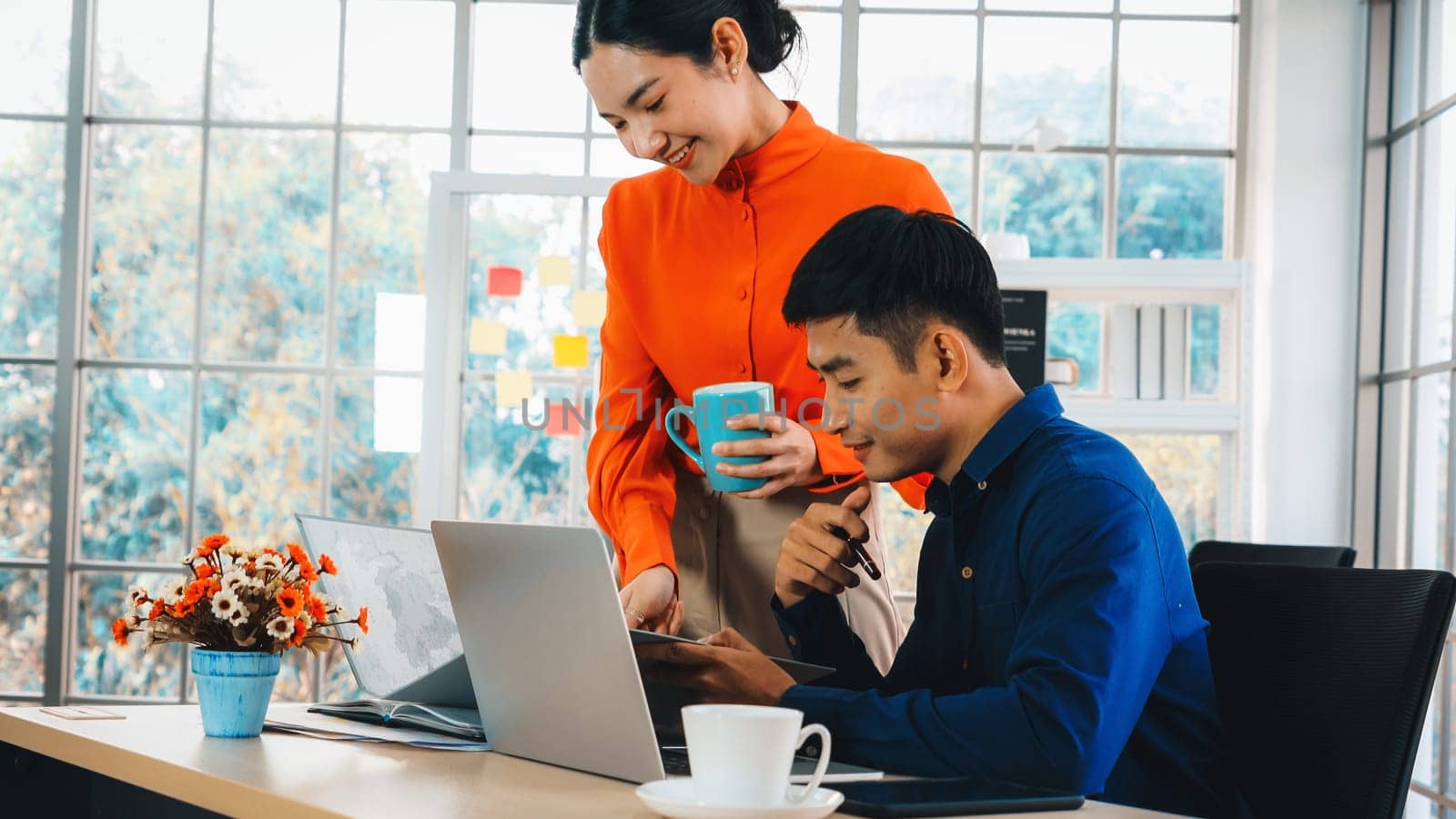 Two business people talk project strategy at office meeting room. Businessman discuss project planning with colleague at modern workplace while having conversation and advice on financial report. Jivy