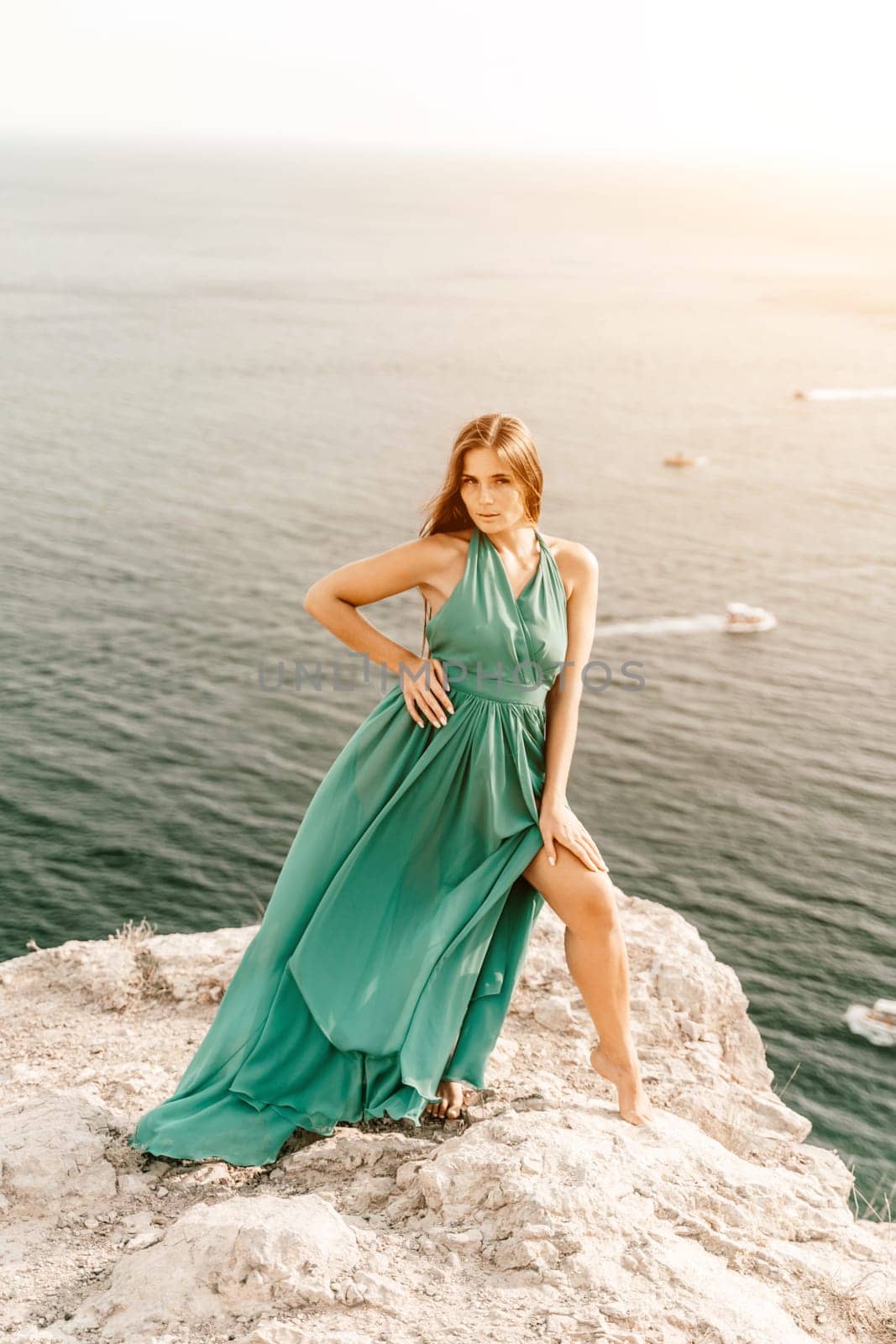 Woman sea trevel green dress. Side view a happy woman with long hair in a long mint dress posing on a beach with calm sea bokeh lights on sunny day. Girl on the nature on blue sky background. by Matiunina