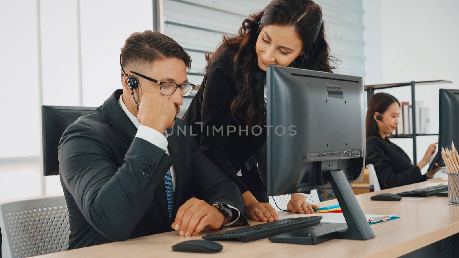 Business people wearing headset working in office to support remote customer or colleague. Call center, telemarketing, customer support agent provide service on telephone video conference call. Jivy