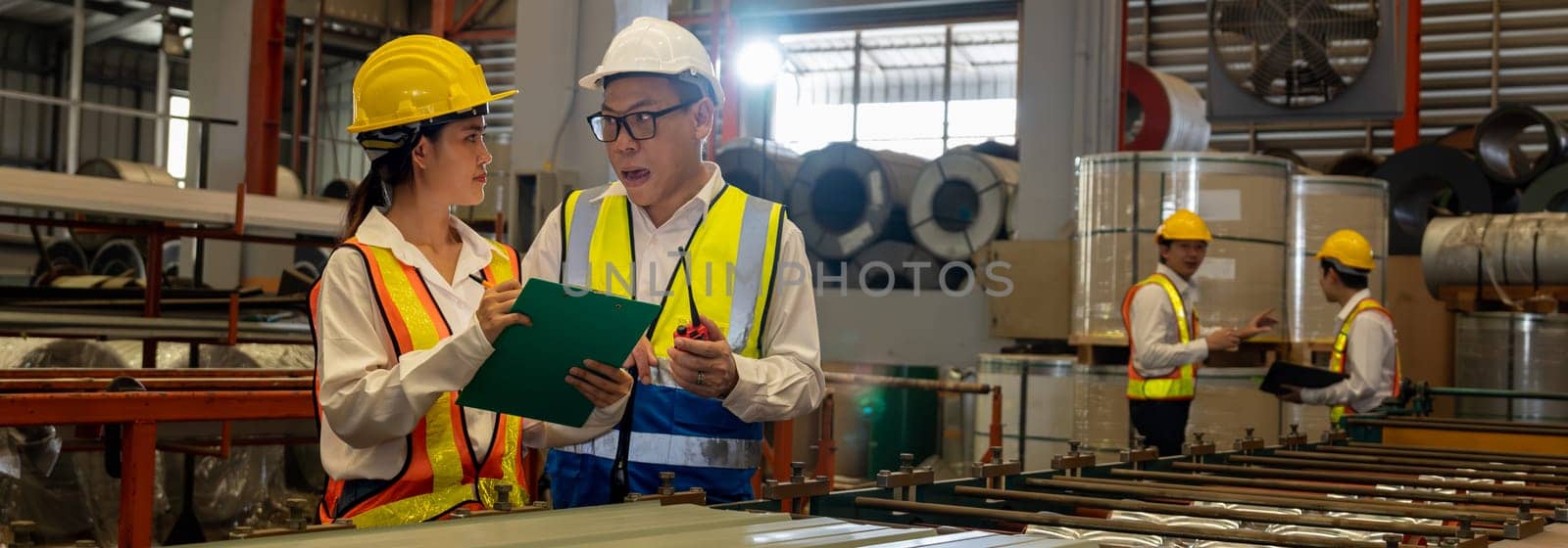 Factory engineer manager with assistant conduct inspection on metal sheet product from industrial machine, exemplifying leadership as machinery engineering inspection supervisor in facility. Panorama