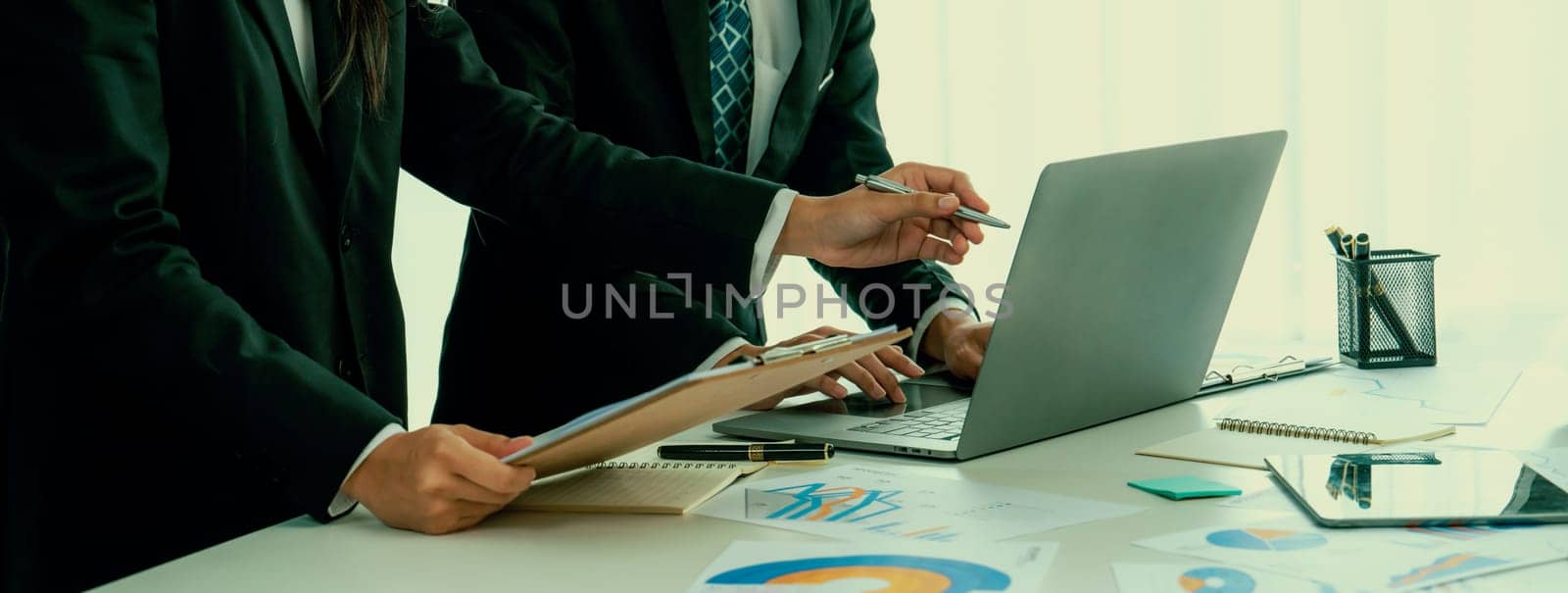 Business people in group meeting in formal attire share idea discussing report for company profit in creative workspace for start up business shot in close up view on group meeting table . Oratory .