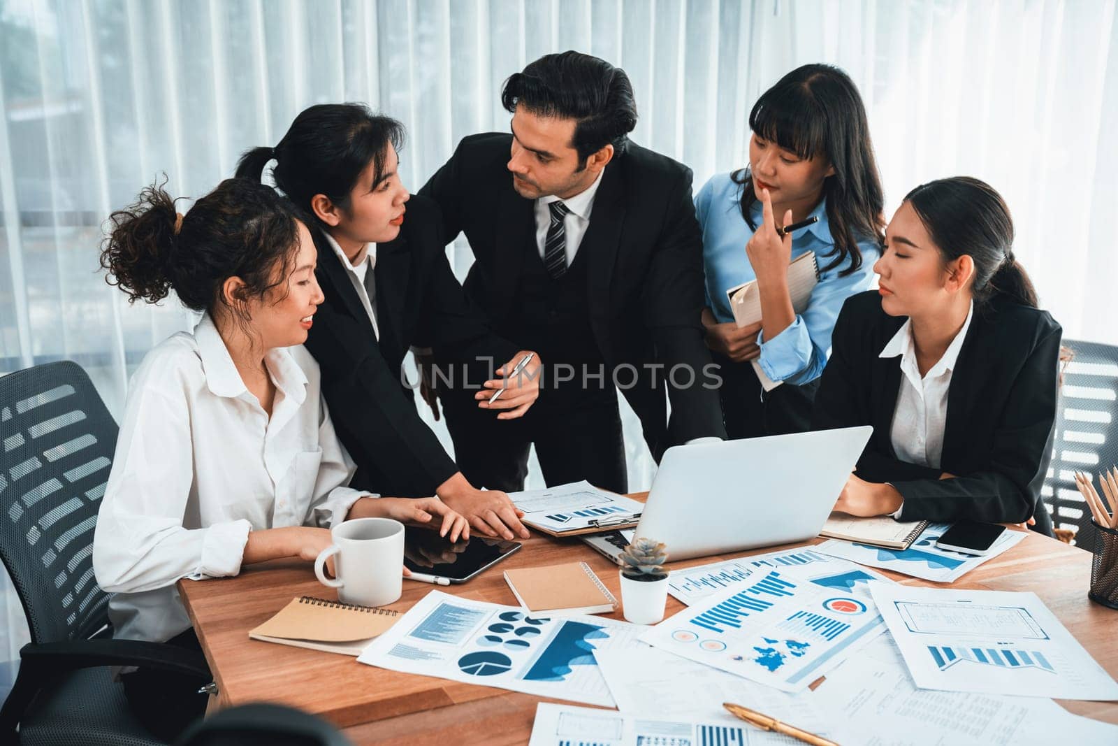 Diverse group of business analyst team analyzing financial data report paper on office table. Chart and graph dashboard by business intelligence analysis for strategic marketing planning Habiliment