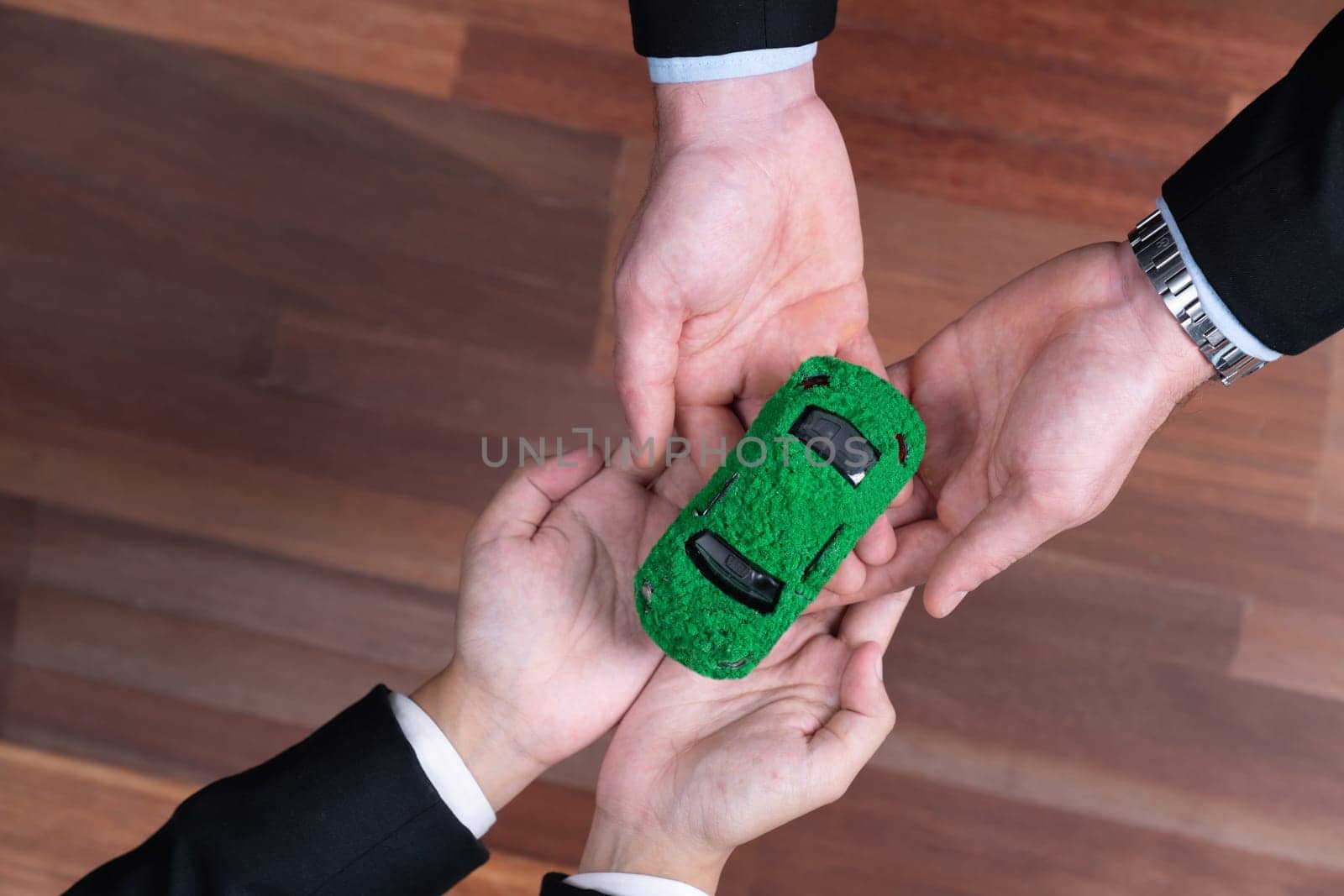 Business people exchange and holding green eco car model. Quaint by biancoblue