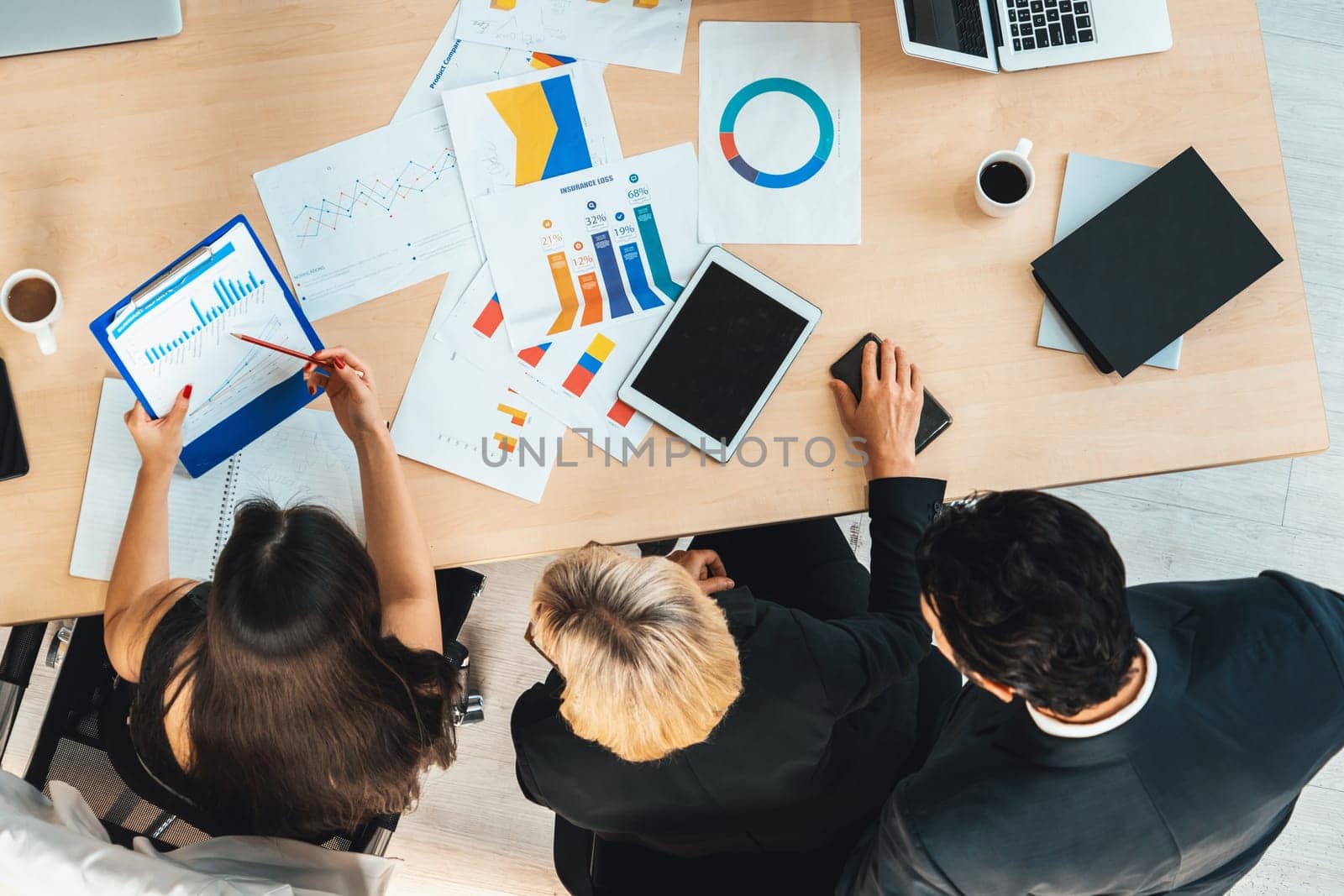 Business people group meeting shot from top view in office . Profession businesswomen, businessmen and office workers working in team conference with project planning document on meeting table . Jivy