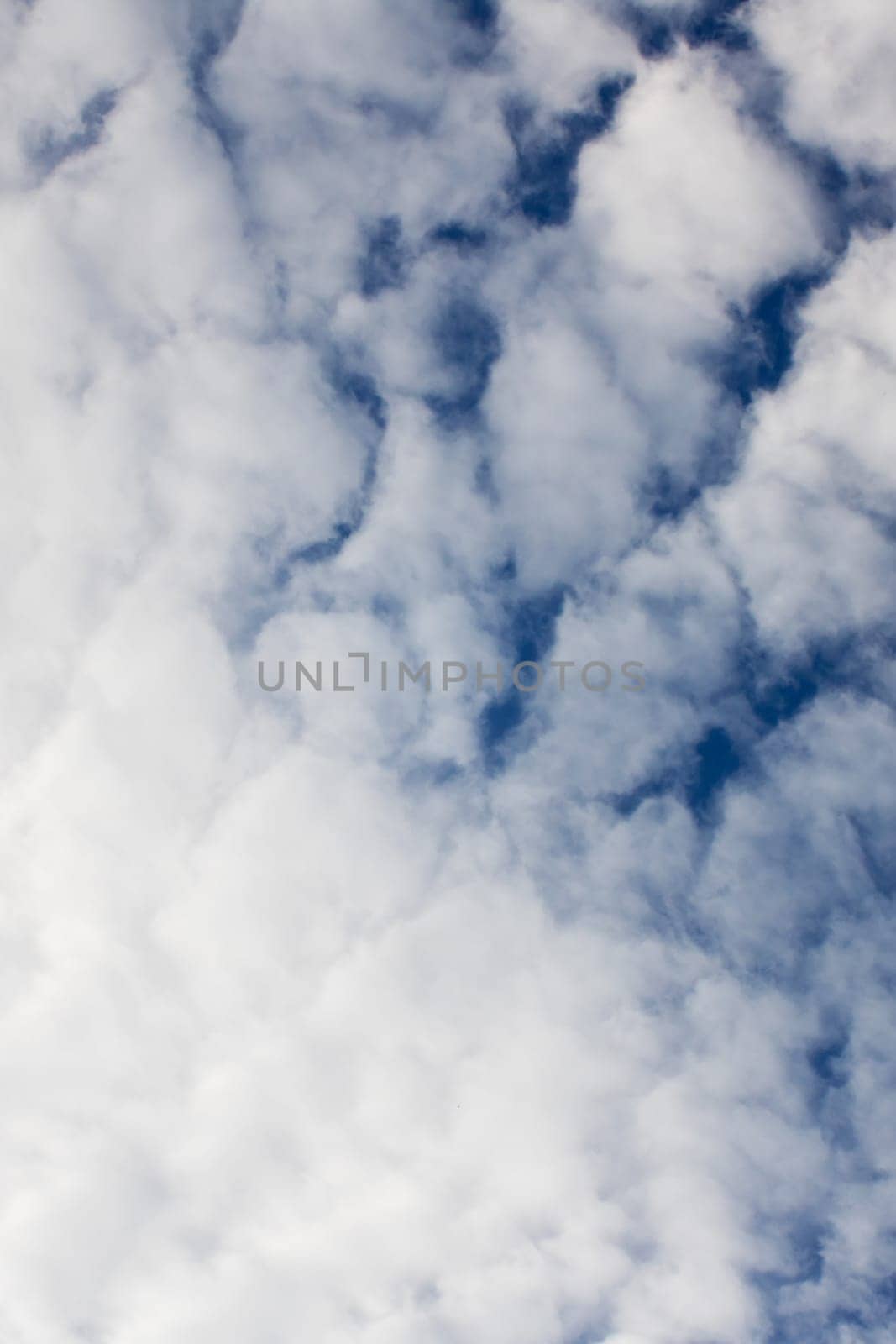 Fluffy clouds in a bright blue sky, natural background