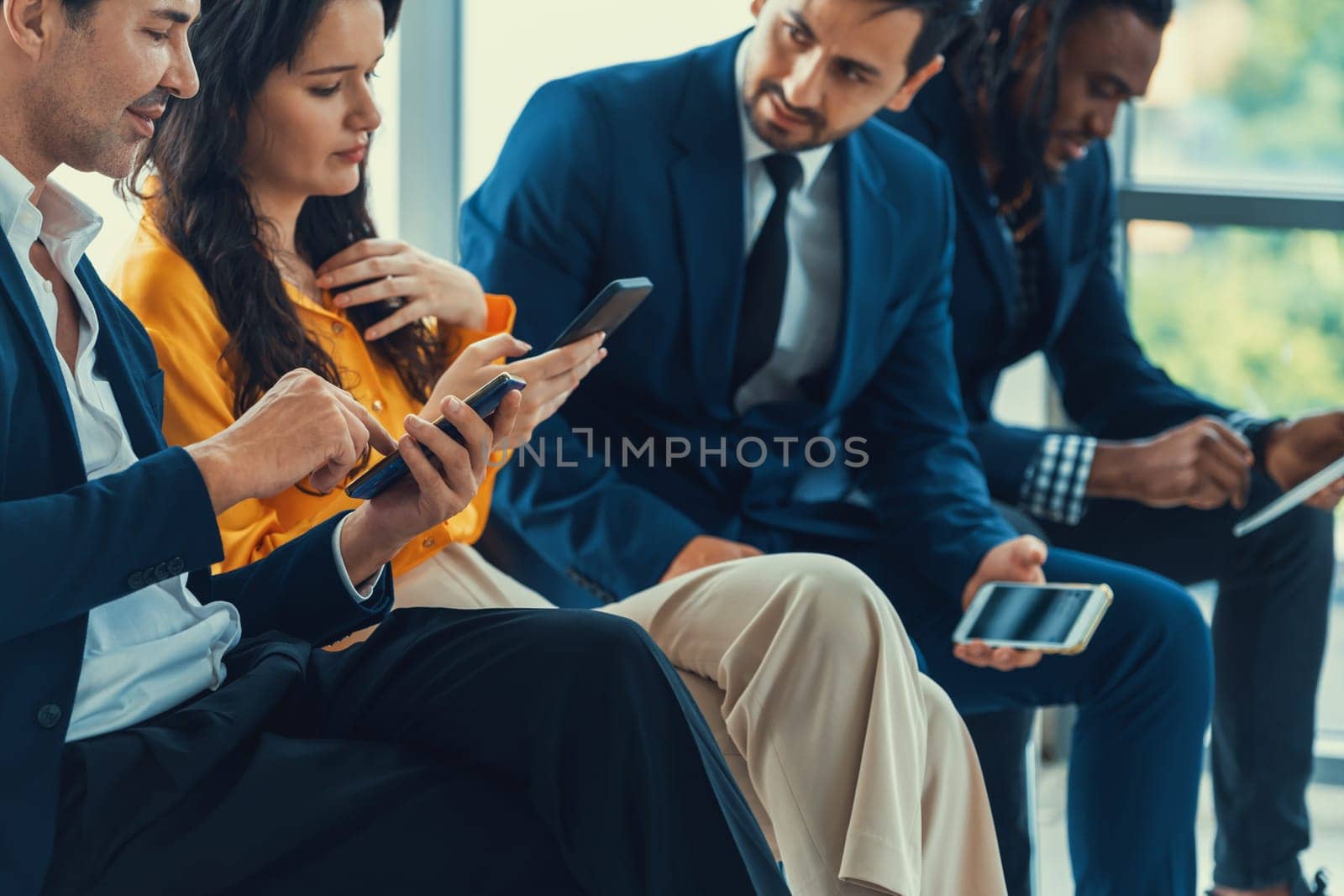 A group of diversity businessman sitting while sharing their data by using smart phone in side view. Smart businesswoman negotiating about finance information with handsome manager. Intellectual.