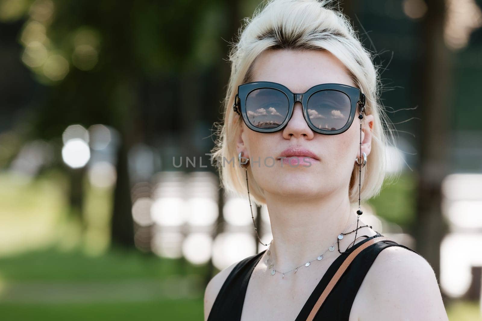Young attractive girl happy positive smile wear sunglass summer nature outdoors.