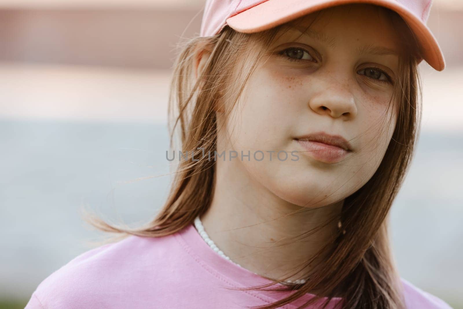 Close up portrait of a ten year old girl, smiling up at the camera. Positive emotion.