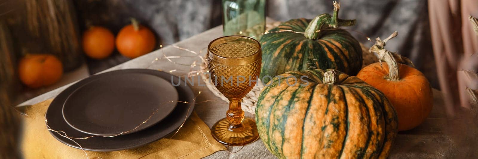 Autumn interior: a table covered with dishes, pumpkins, a relaxed composition of Japanese pampas grass. Interior in the photo Studio. Close - up of a decorated autumn table by Annu1tochka
