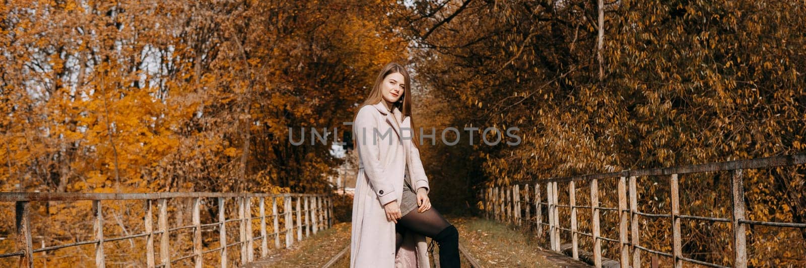 beautiful long-haired woman walks through the autumn streets. Railway, autumn, woman in a coat. by Annu1tochka