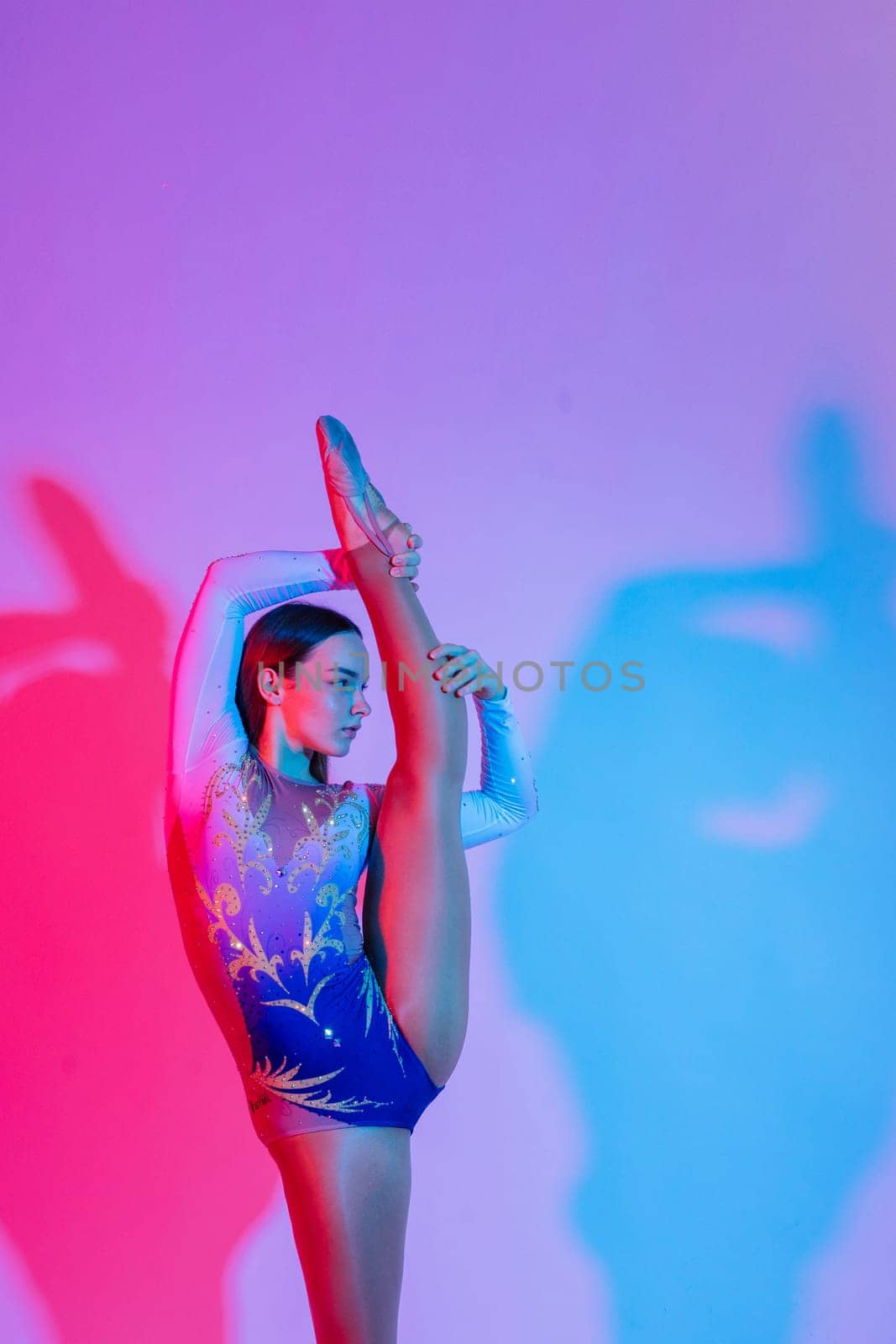 Portrait of beautiful young woman gymnast training calilisthenics exercise with acrobatic element by Zelenin