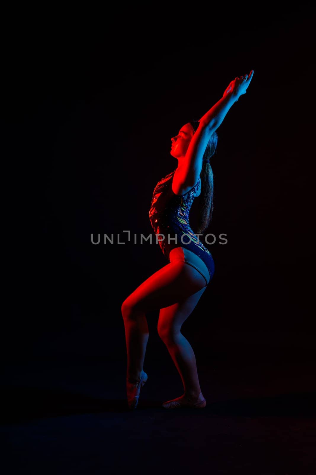 Portrait of beautiful young woman gymnast training calilisthenics exercise with acrobatic element by Zelenin