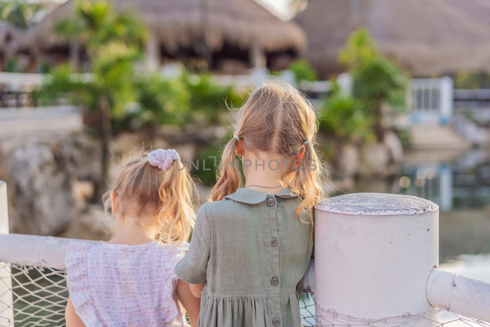 Two little girls take a delightful stroll along the yacht marina, their faces filled with wonder as they explore the world of boats and the sparkling waters by galitskaya