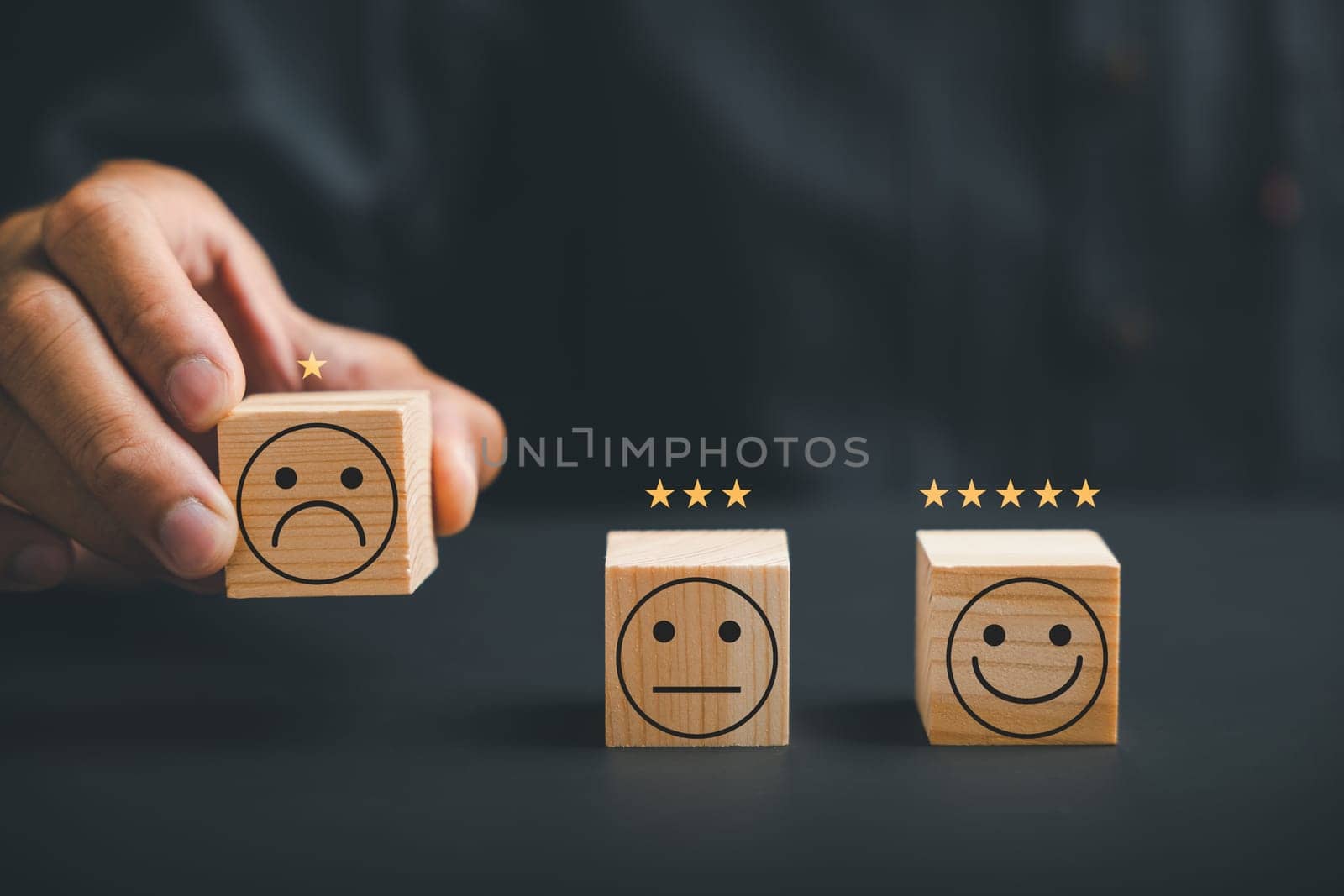 Unhappy customer hand with a sadness emotion face on a wooden block by Sorapop