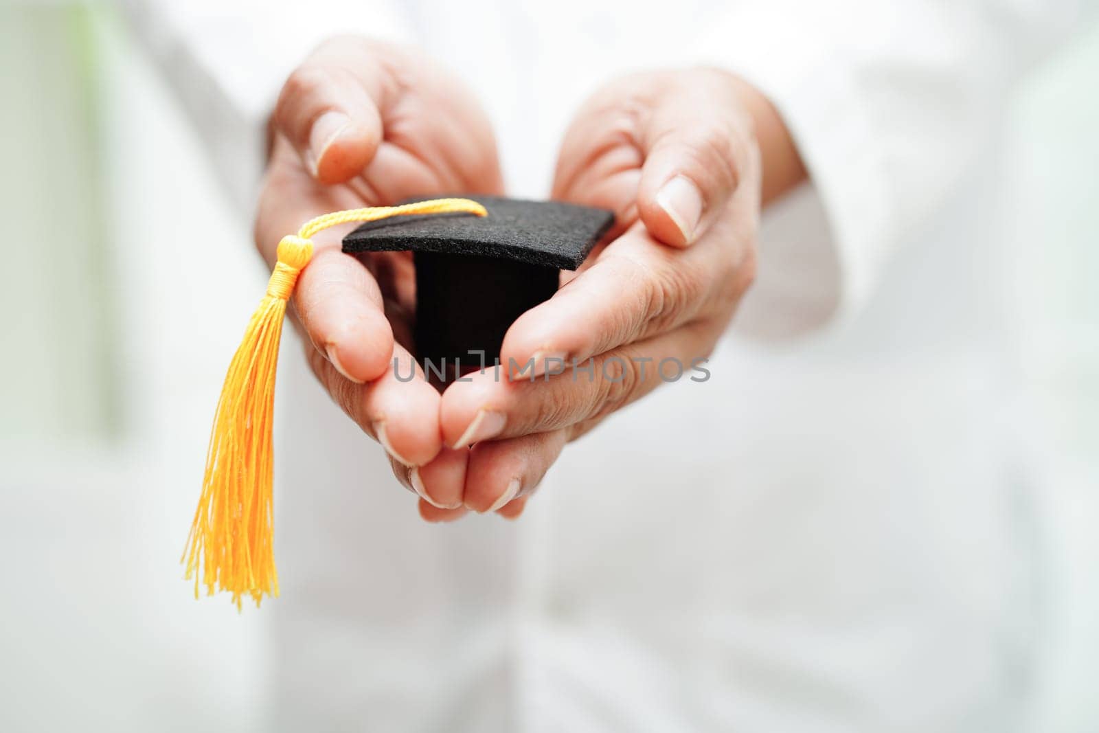 Asian woman doctor holding graduation hat in hospital, Medical education concept.