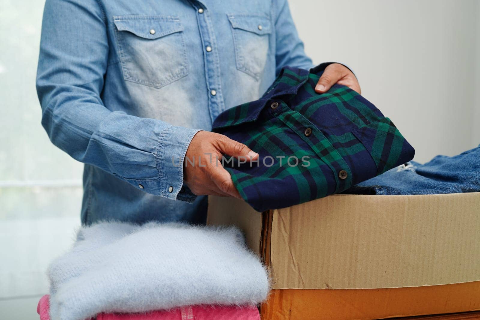 Clothes donations in cardboard box for volunteer.