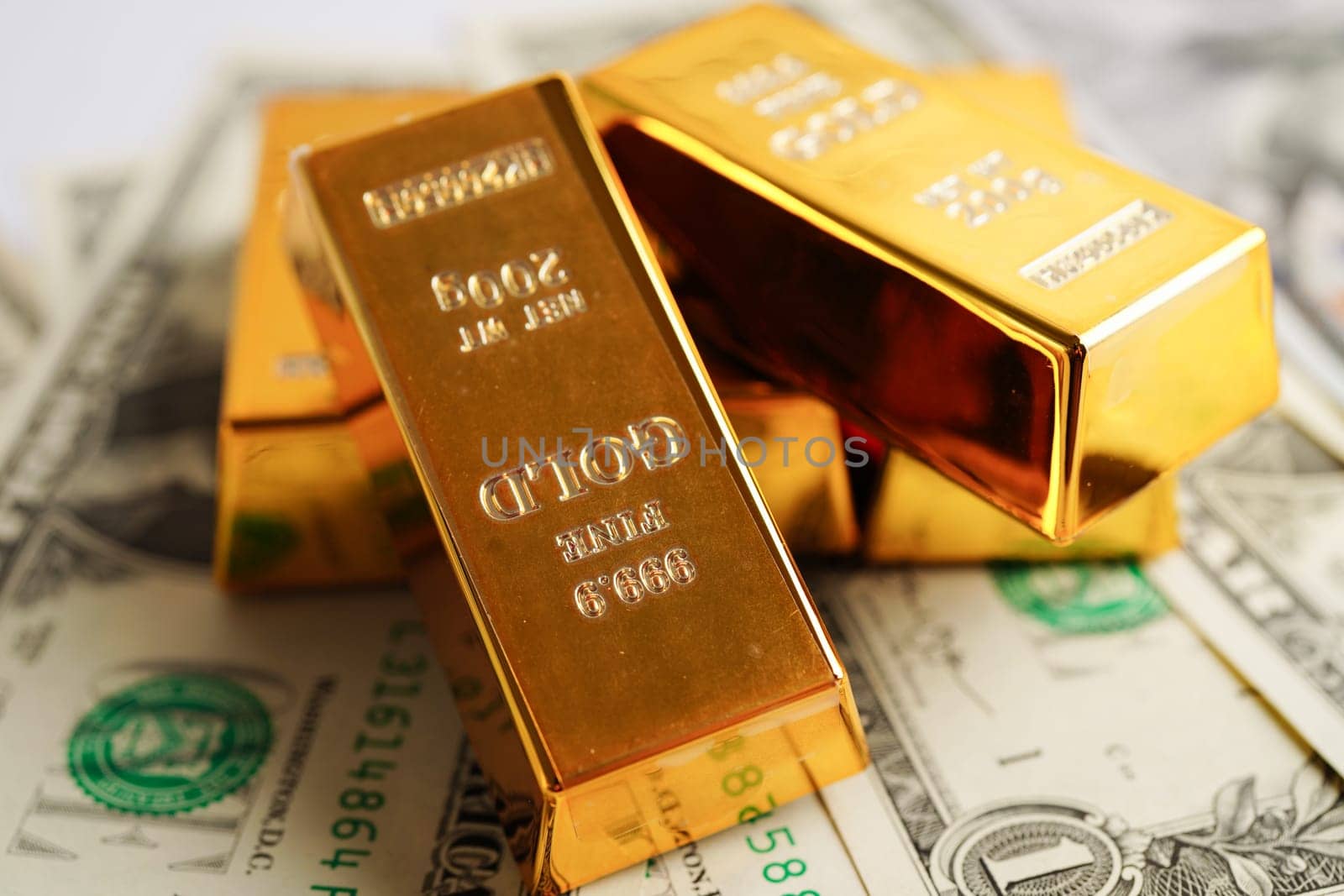 Gold bars on US dollar banknote money, finance trading investment business currency concept.