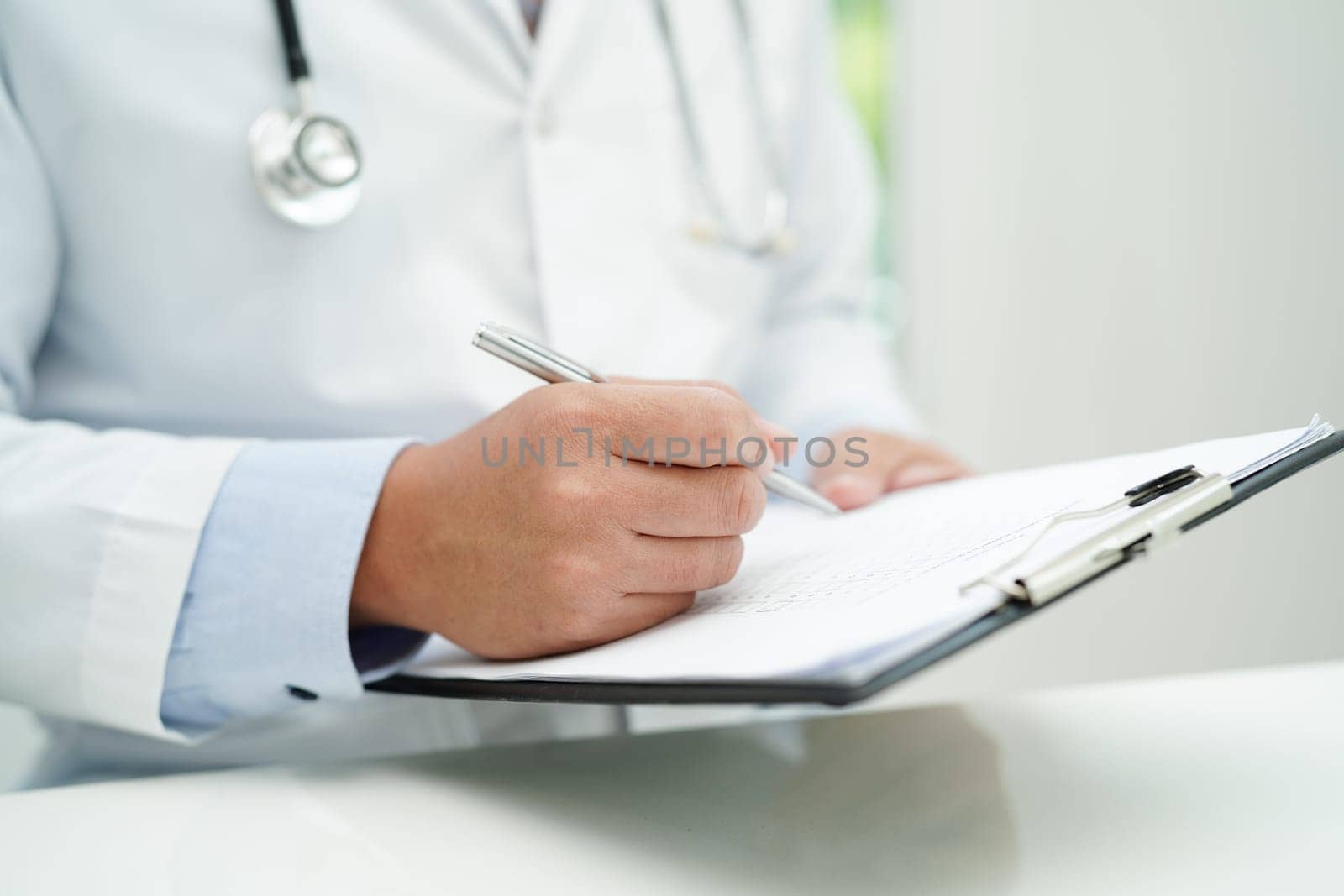 Asian man doctor study document to research method and technic for treating patients.