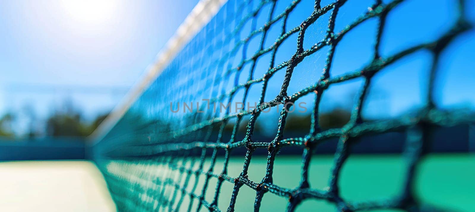 A close-up view of a badminton net in the process of being set up, silhouetted against a vibrant blue sky. the scene captures a sense of preparation and readiness, with a blurred background a sunny day on the sports court.