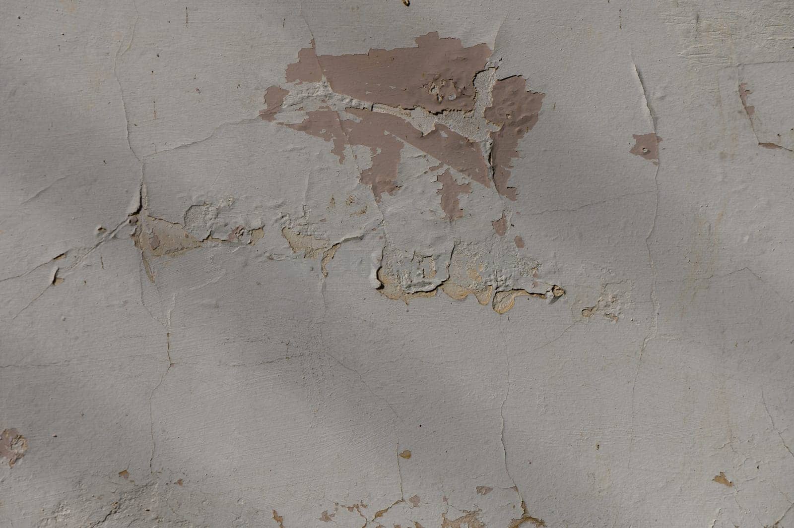 Layers of cracked paint and peeling plaster showcase the beauty of aging walls in an old urban setting.