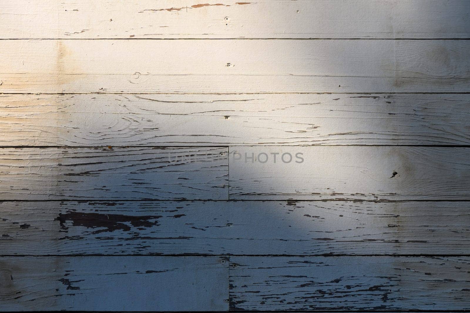 Soft sunlight illuminates aged wooden planks, creating a serene atmosphere with intricate shadows and textures.