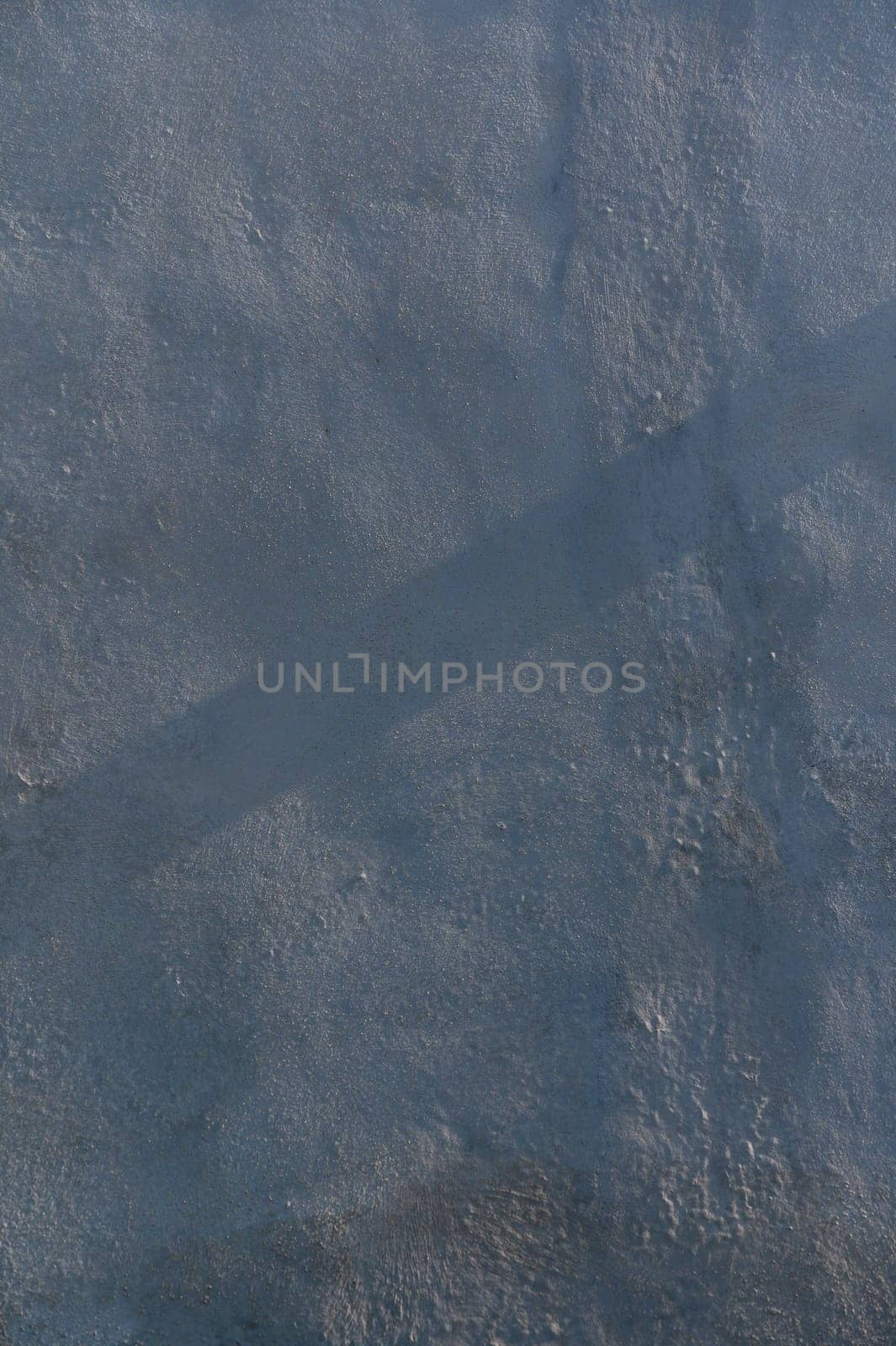 Rays of morning light dance across a textured surface, highlighting intricate patterns and shadows in cool tones.