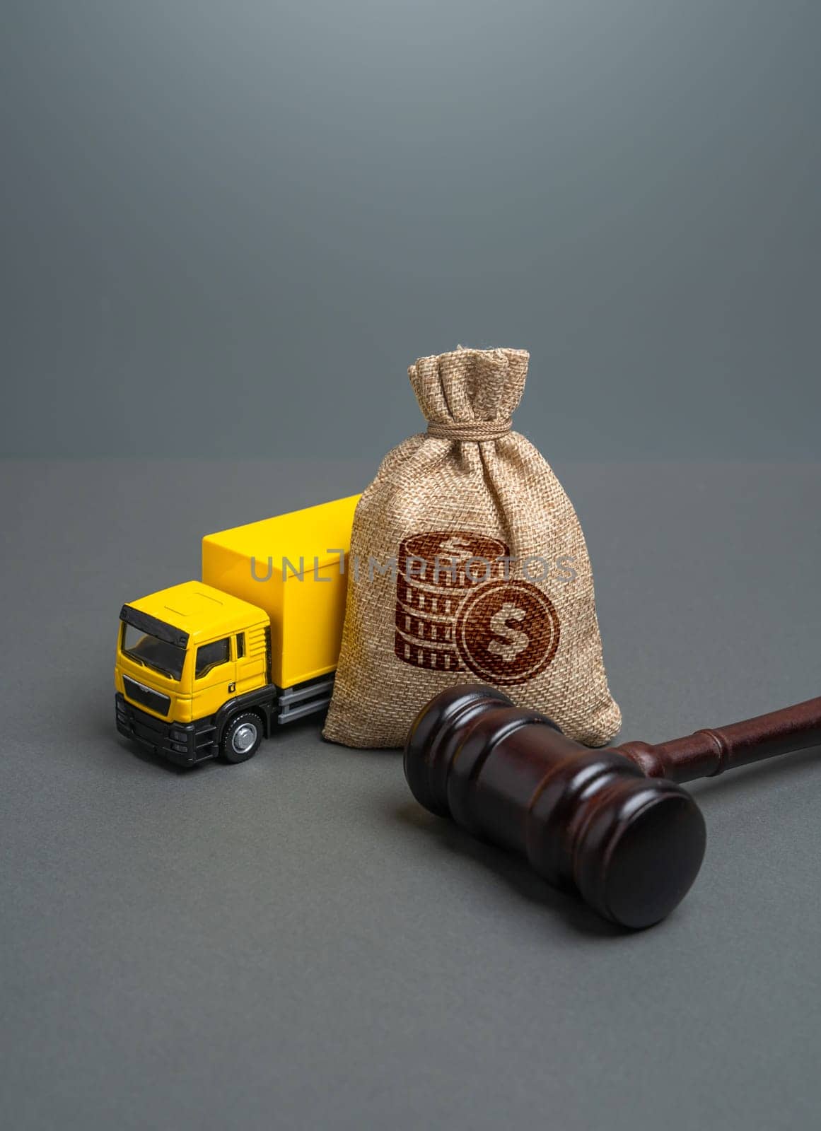 A transport truck and a money bag with a judge's gavel. Litigation of transport companies. Fines and deductions. Legislative regulation of freight transportation.