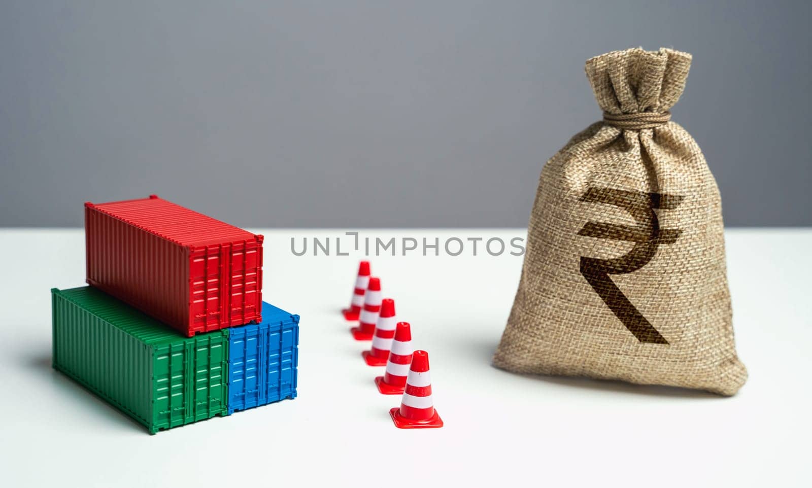 Shipping containers with goods and indian rupee money bag are separated by a barrier. Economic sanctions. Break a trade deal. Naval blockade. Logistics difficulties.