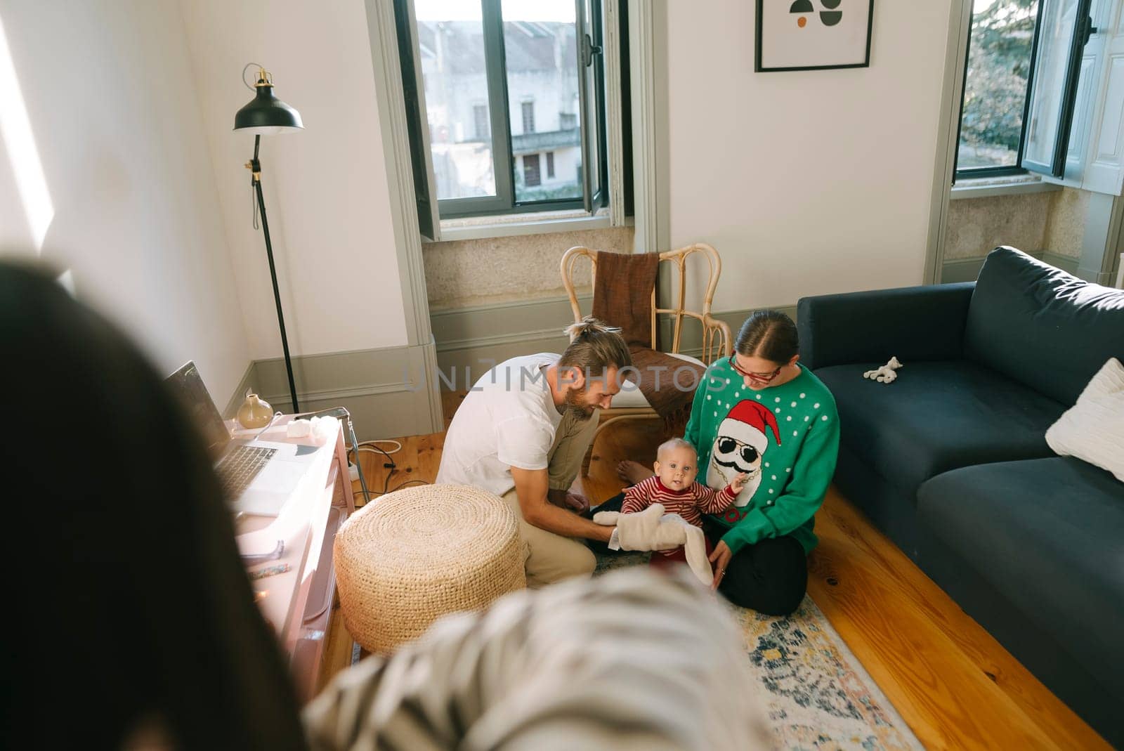 A family gathering with parents enjoying quality time with their adorable baby in a warm, cozy living space